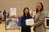 Above: Friedman presents a certificate of recognition to 1st place winner Mela Gainer and her piece, "Out of Water.”