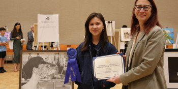 Above: Friedman presents a certificate of recognition to 1st place winner Mela Gainer and her piece, "Out of Water.”